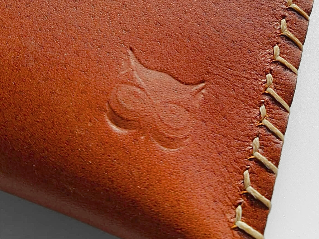 Hand-stitched cognac leather pouch with the embossed OWL logo